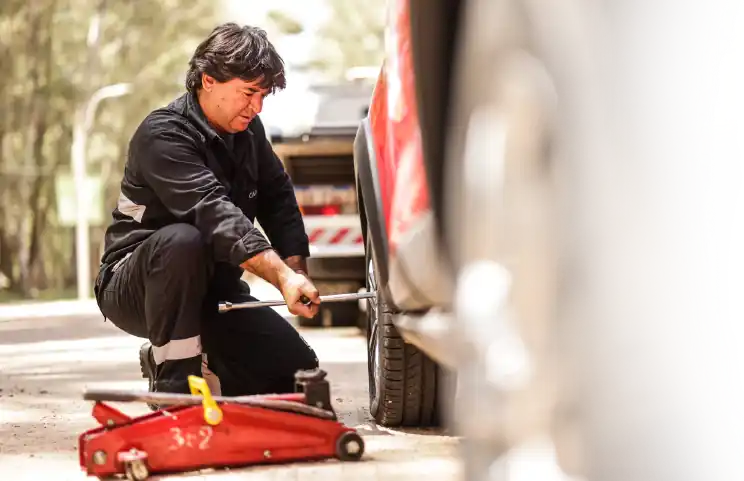 empleado de car up cambiando un neumático de un auto